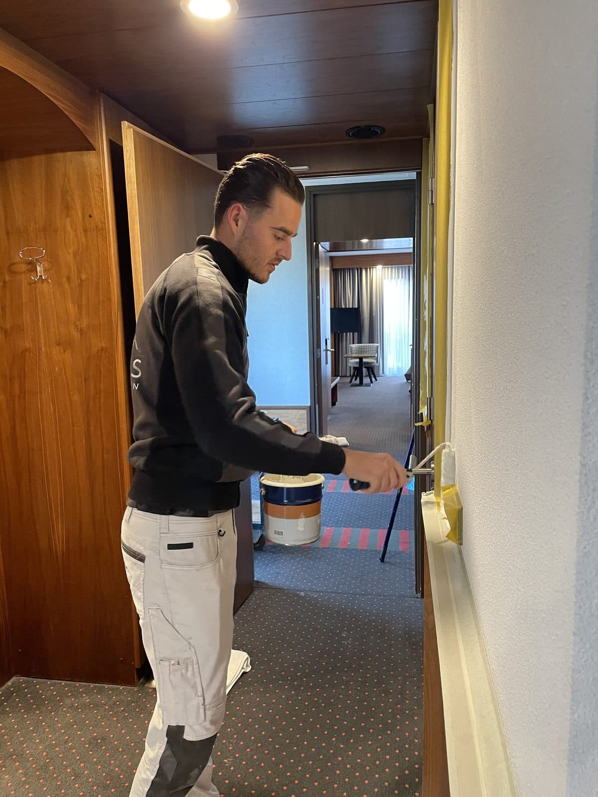 Schilder van Maes Schilderwerken aan het werk in hotelgang bij Van der Valk Hotel