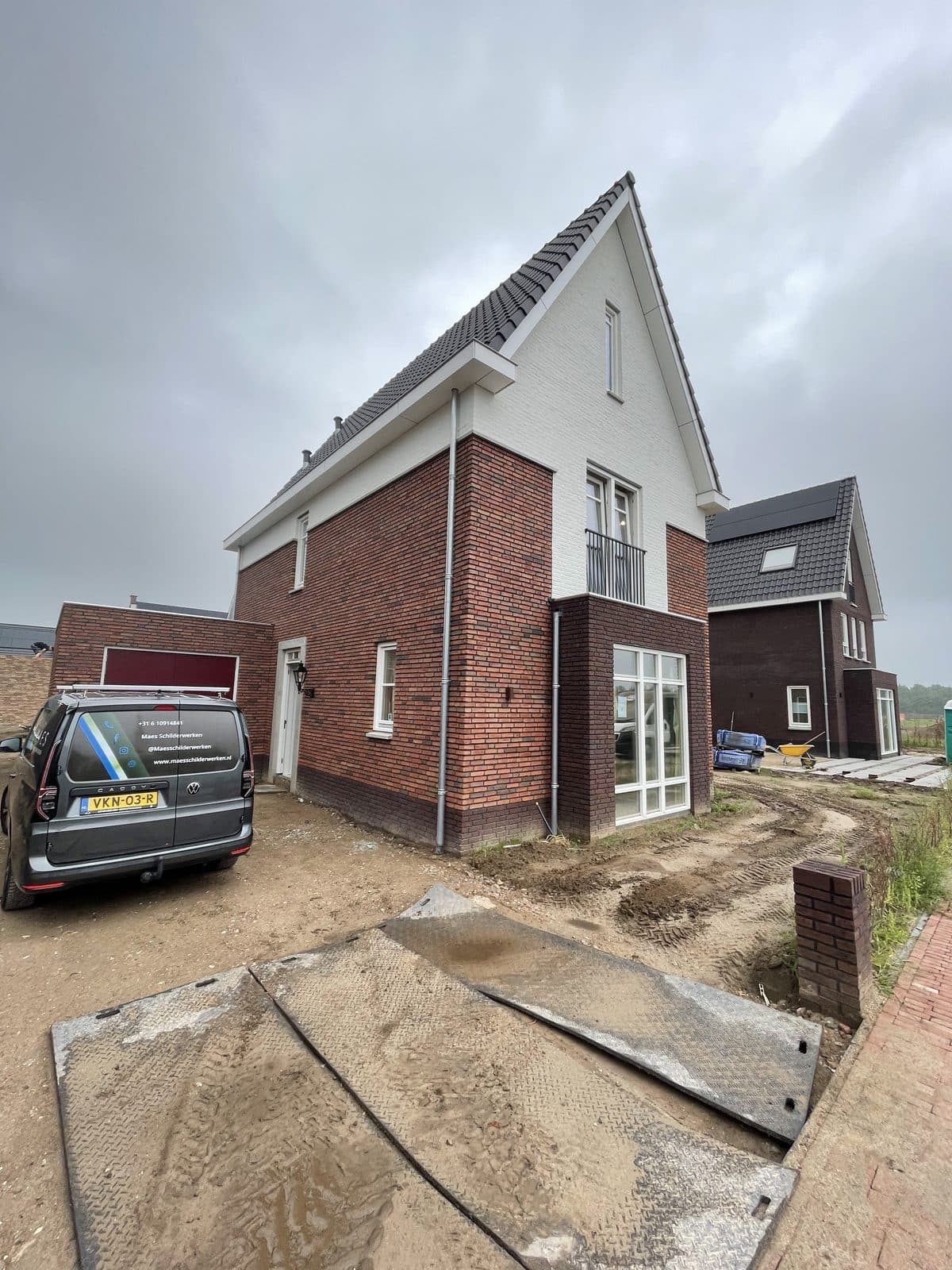 Nieuwbouwwoning met bakstenen gevel en Maes Schilderwerken bus